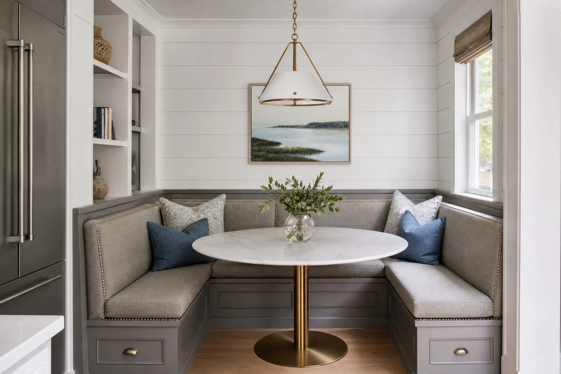 Booth-style breakfast nook with marble-top table and shiplap wall